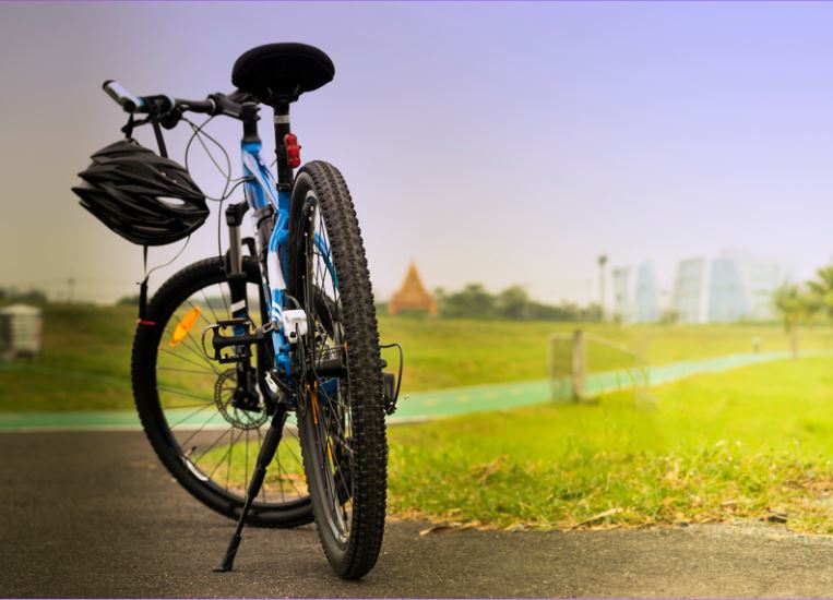 Bicycle standing up with a view towards a field